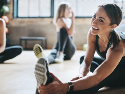 Having a laugh while limbering up Shot of mature women stretching with a young female instructor during a training class at the gym